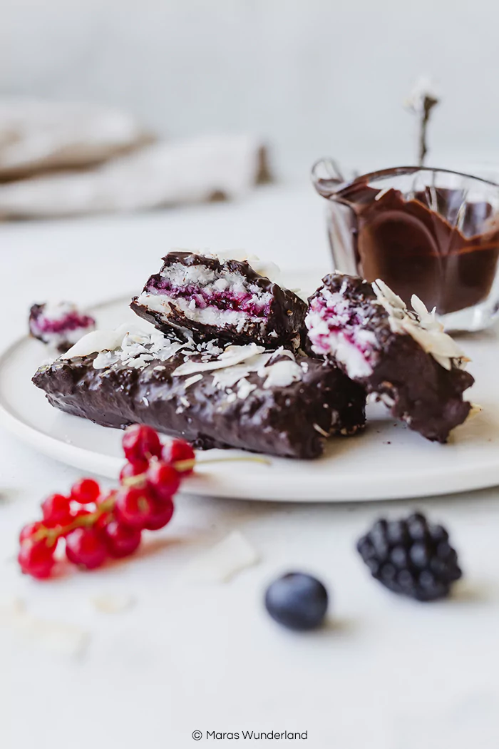 Gesunde, vegane Beeren-Kokosriegel. Rezept für einen schnellen und einfachen Snack für den Sommer. Fruchtig und super erfrischen mit Marmelade in der Mitte. • Maras Wunderland #bounty #bountys #kokosriegel #coconutbars #sommersnack #healthysnack #vegansnack #eatvegan #eathealthy #maraswunderland